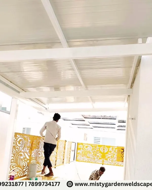 The installation of decorative CNC panels on a pergola at Natura Atavi. The golden-yellow panels add a vibrant and luxurious touch to the white structure.
