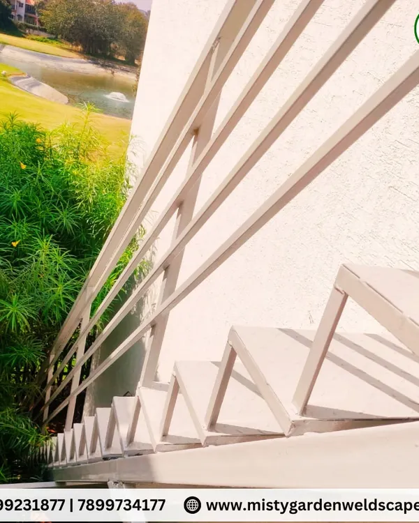 A sleek and modern metal staircase with a simple, clean railing design. This outdoor staircase at Prestige Augusta Golf Village provides access while maintaining a minimalist aesthetic that complements the lush green surroundings.