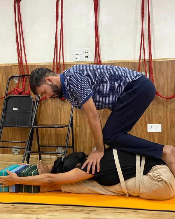 This is what my teaching is all about: providing hands-on, supportive adjustments to help you safely deepen your practice. Using props like blocks and straps, we work together to find alignment and release tension in a forward bend.