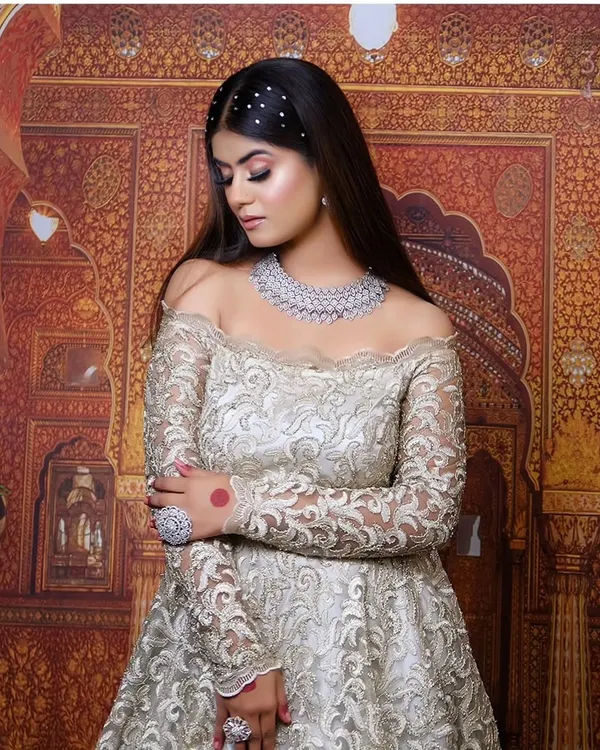 This elegant off-shoulder gown with intricate silver embroidery is perfect for a reception or engagement shoot. It pairs beautifully with our American Diamond jewellery.