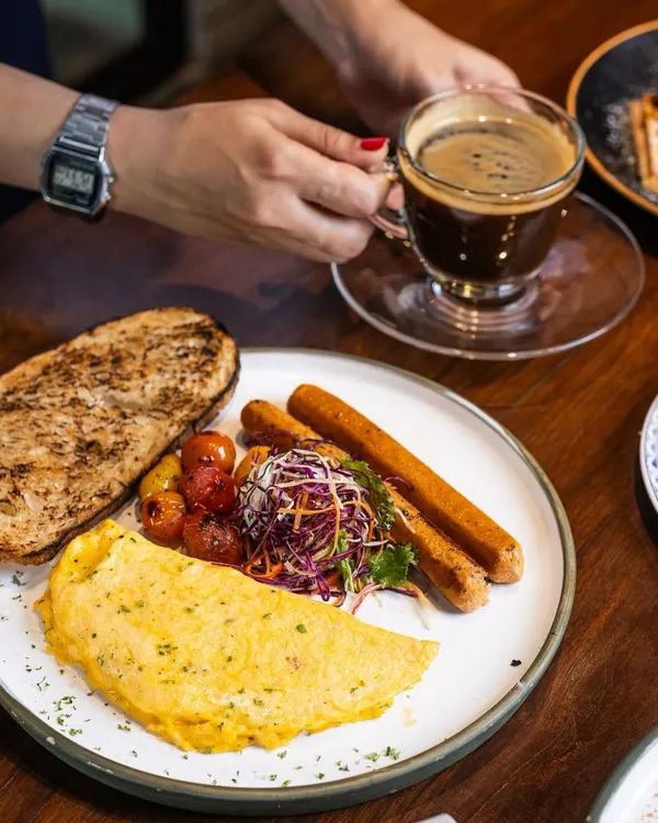 This is exactly how I believe a good morning should begin. A fluffy omelette, savory sausages, roasted cherry tomatoes, and a slice of perfectly toasted bread, paired with a strong, hot coffee. It’s a simple plate that feels like a hug.
