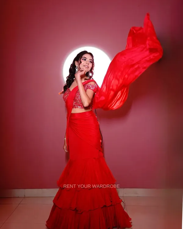 The highlight of this red drape saree is the dramatic, flowing pallu. This shot captures the movement and makes the outfit look so dynamic and glamorous.