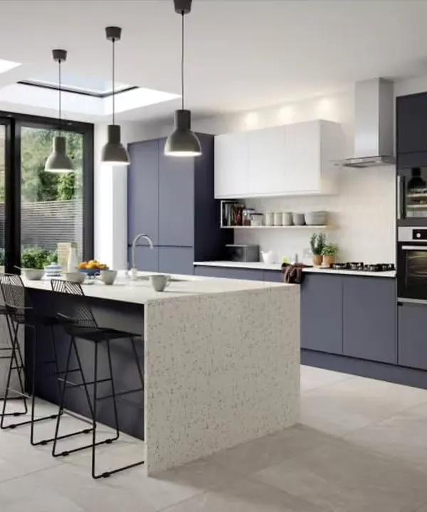 We designed this open-plan kitchen to be the heart of the home. The large island with a terrazzo-style quartz countertop provides ample space for meal prep and casual dining, while the matte navy blue cabinets and integrated ovens create a sleek, modern look.