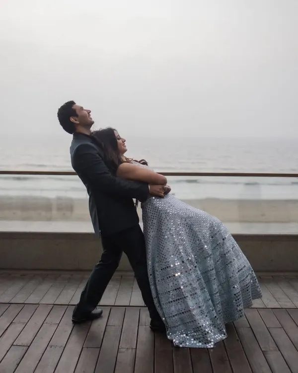A moment of pure, carefree joy. This playful dip on a seaside deck captures the fun and spontaneity we love to encourage in our shoots. It's all about having a great time together.