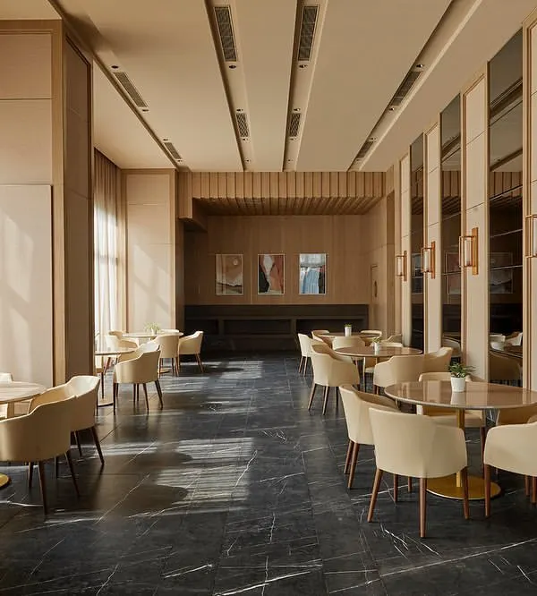 The main dining and gathering space in the Elemental banquet hall, featuring a trapezoidal floor plan with an acoustically treated ceiling and abundant natural light from the glass façade.