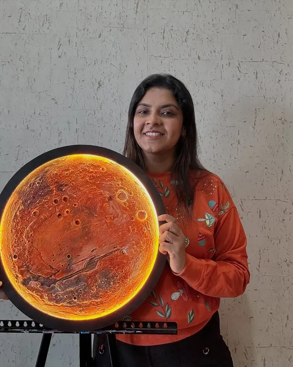 The finished Mars lamp, glowing with its integrated LED backlight. The light catches the textured craters and canyons, creating a warm and dramatic effect. This piece is a conversation starter.