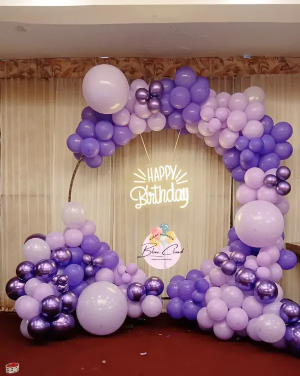 A beautiful organic balloon garland on a ring frame in shades of purple, perfect for a birthday party.