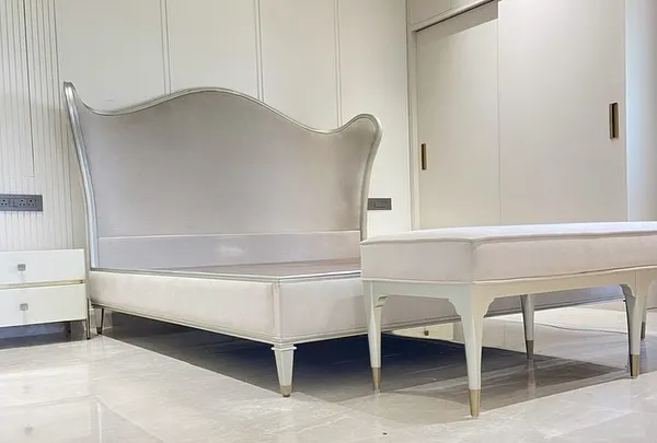 This Bedtime Beauty offers regal style with its dramatically updated camel-back headboard and generous curving wings. The exposed, exquisitely carved wood rail is finished in a radiant Auric silver leaf and upholstered in a luxury fabric for refined elegance.
