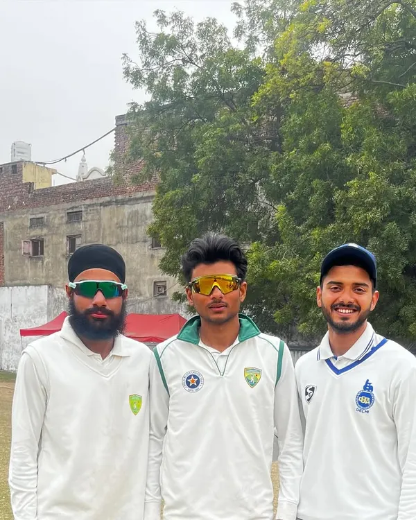 Three of our academy players, representing both Delhi Blues and Neo Sports clubs, stand together on the field. This showcases the pathway we provide for competitive cricket.
