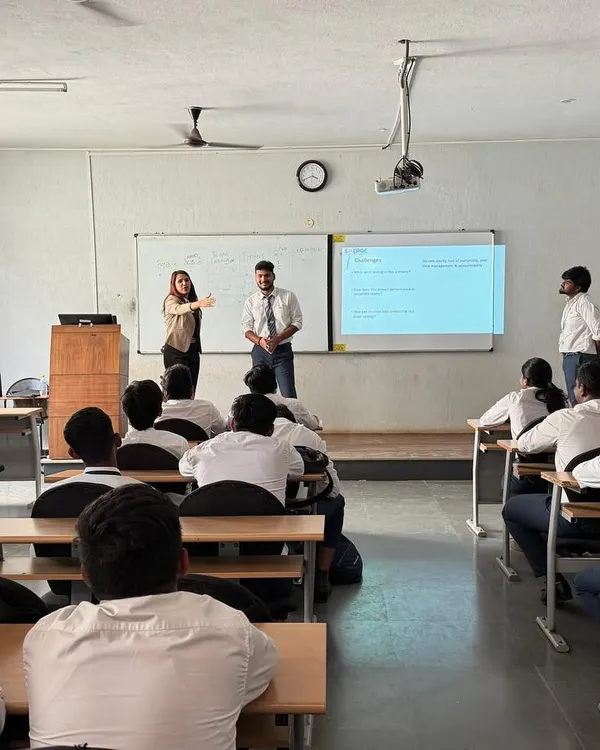 Here, I'm guiding a student through a presentation exercise in front of the class. Building confidence comes from doing, and these practical sessions are key to overcoming public speaking anxiety.