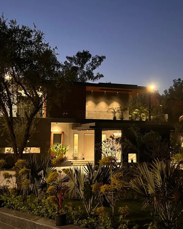 At night, the landscape lighting at "The One" residence transforms the home. Uplighting on the trees and soft lights within the garden beds create a warm, inviting glow that highlights the textures of the plants and the modern lines of the architecture.