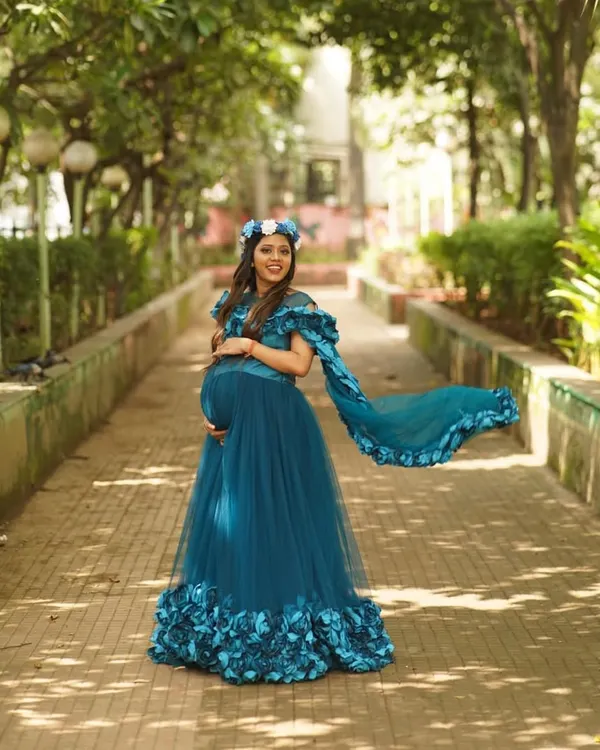 This is one of my most popular maternity photoshoot gowns, and you can see why. The flowing teal tulle and dramatic train create beautiful movement in photos, while the 3D floral details on the hem and shoulders add a touch of fairytale magic. It's perfect for an outdoor session where you want to feel like a queen.
