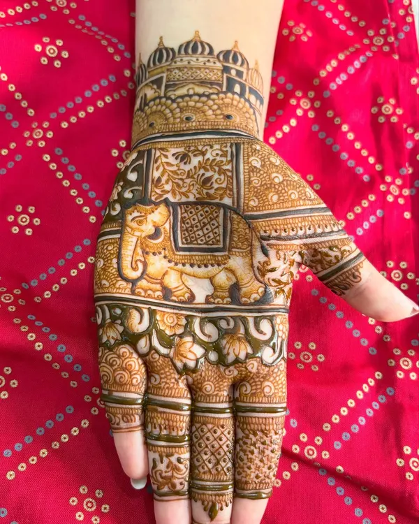 A classic design featuring a royal elephant on the palm, with a palace dome design on the wrist. The intricate filler patterns around the main motif make the hand look full and festive.