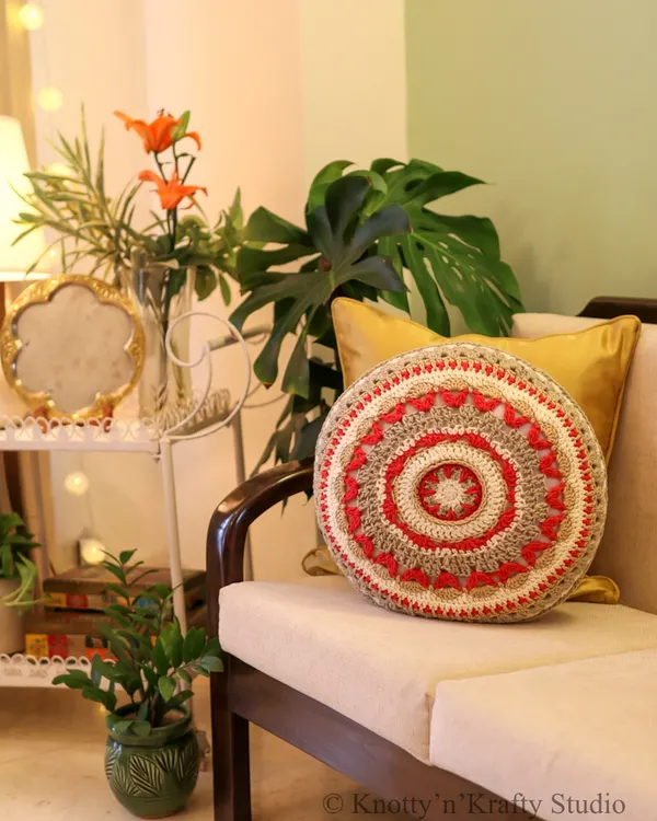 This round crochet cushion is designed to be the heart of a cozy corner. I love how its pop of colour and handmade charm, paired with a satin pillow and soft lighting, turns a simple sofa into an inviting nook. It’s these layers of love that make a house feel like home.