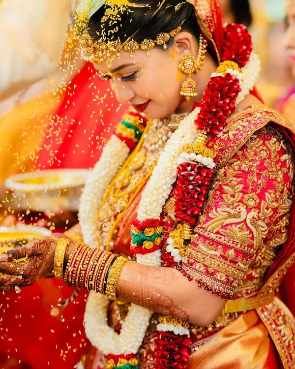 A bride's muhurtham is a sacred moment, and this look was designed to honor it. The rich red Kanchipuram silk is complemented by a heavily embroidered blouse featuring traditional peacock motifs in zardozi and beadwork, creating a timeless bridal heirloom.