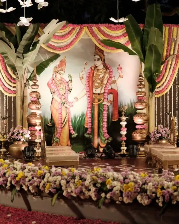 A traditional South Indian wedding stage setup at our ashram. The decor features banana leaves, marigold garlands, and brass lamps, with a beautiful illustration of a divine couple, creating a truly sacred ambiance for the ceremony.