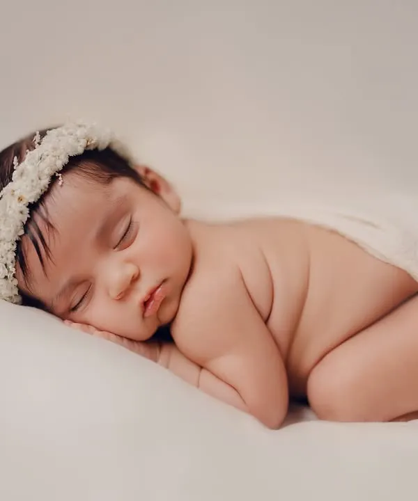 The classic newborn pose. This simple, beautiful portrait focuses on the baby's peaceful expression and tiny features, wrapped gently in a soft cloth. It's a timeless way to remember how small they once were.