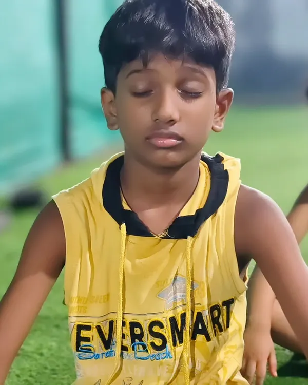 A young athlete finds a moment of calm and focus during a group meditation session.