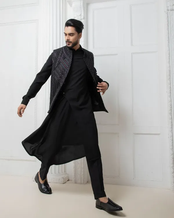 I design for movement and impact. This black Indo-western set features a hand embroidered jacket over a fluid, draped kurta, offering a modern and dynamic option for a sangeet or reception.