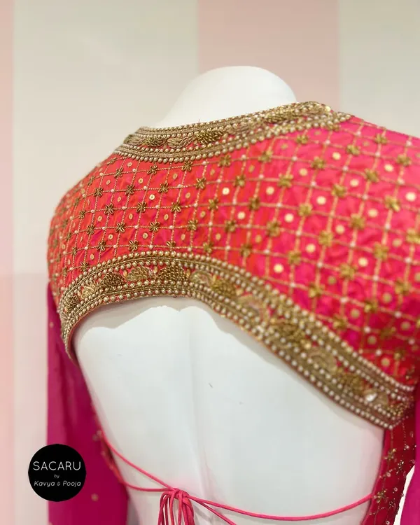 This backless, full-sleeve blouse features an elaborately embroidered panel, creating a look that is both dramatic and elegant.