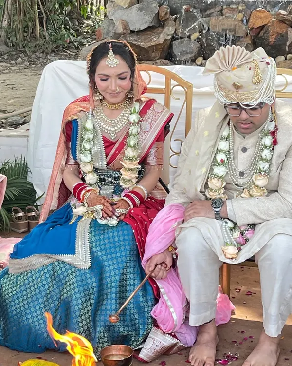 A beautiful moment from a client's wedding ceremony. She is wearing a custom-designed Tehhzeeb bridal lehenga, combining a blue brocade skirt with a traditional red dupatta for a timeless look.