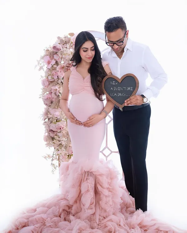 A sweet announcement for your next chapter. This couple's portrait uses a fun prop and a beautiful floral arch to celebrate the adventure ahead, all wrapped in a soft, romantic aesthetic.