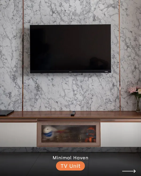 This minimalist TV unit combines a luxurious marble-finish backdrop with warm wood and elegant fluted glass. It's a perfect example of how we blend textures to create a clean, sophisticated look while providing ample storage.