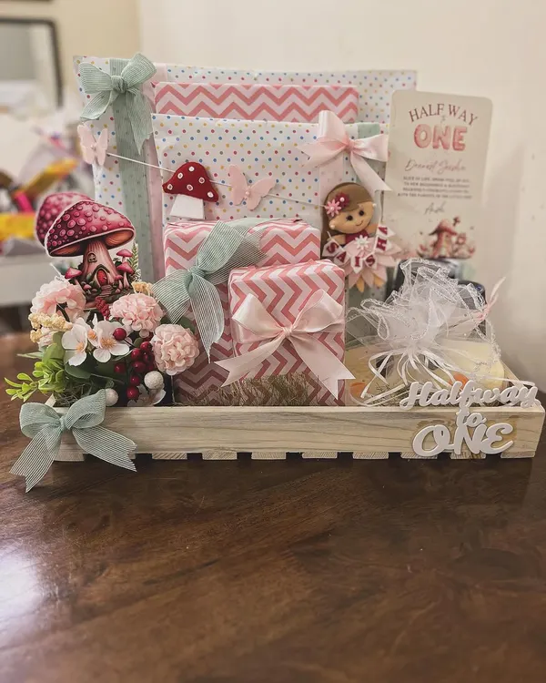 I love celebrating all the little milestones, including the quirky ones. This "Halfway to One" hamper was designed for a six-month celebration, using a whimsical fairy and mushroom theme to create a magical gift for a baby girl's special day.