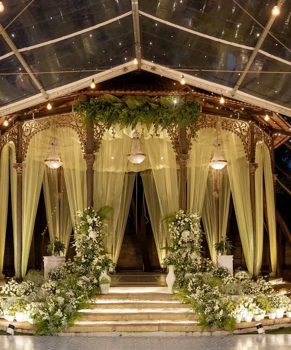 The Colonial Bandstand, transformed by night into a magical stage for a Sangeet, with warm lights reflecting off the dance floor and lush greenery. This is where stories begin under a canopy of stars.