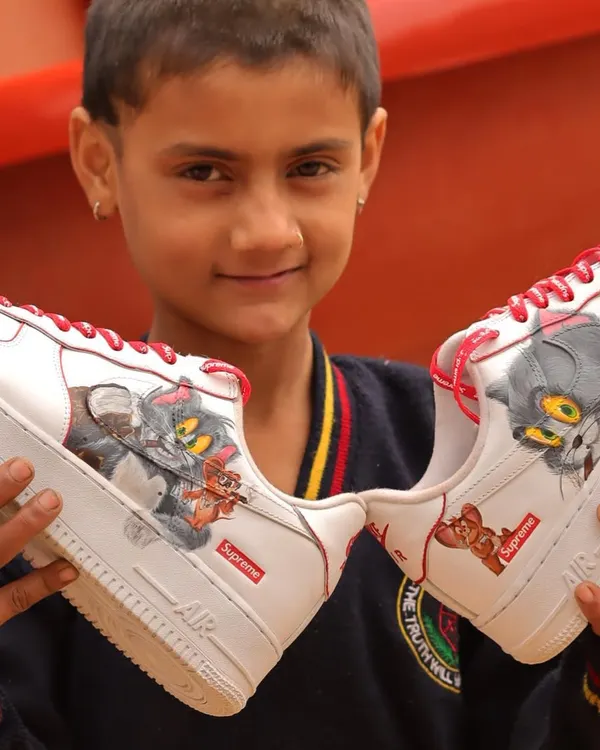 Sometimes the best photoshoots are the ones you don't plan. This kid's smile says it all. Here he is holding the Tom and Jerry themed Nike Air Force 1 Supremes I painted.