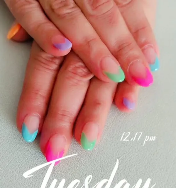 A close-up of the multi-color French tip design, showing the blend of neon and pastel shades on each nail.