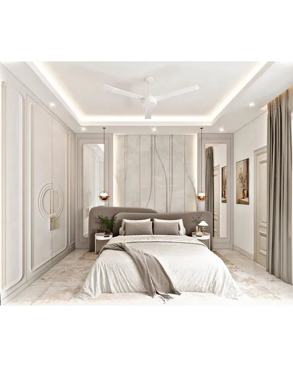 A luxurious and symmetrical bedroom design featuring paneled walls and integrated wardrobes. The soft grey tones, plush headboard, and elegant pendant lights come together to create a sophisticated and tranquil atmosphere.