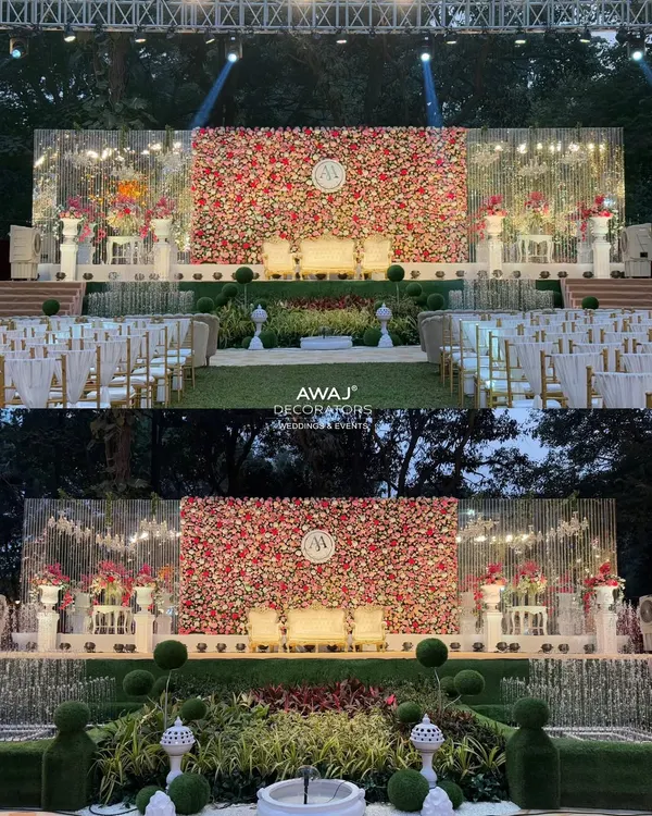 A spectacular day-to-night view of a wedding stage featuring a massive wall of red, pink, and white roses, complete with a custom monogram and elegant seating for the couple.