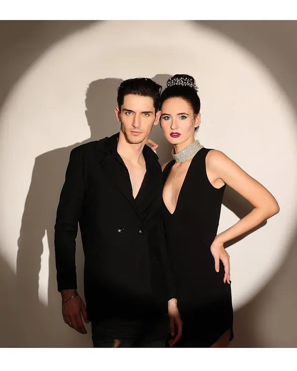 A glamorous power couple portrait, with both models dressed in black and posing in a dramatic spotlight. This showcases my ability to create high-fashion, editorial-style images for two.