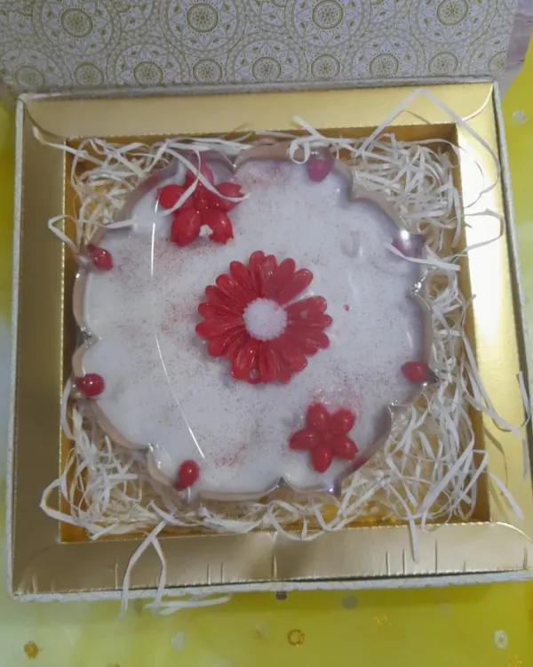 Make this Diwali unforgettable with a stunning urli at the heart of your rangoli. This one features a large red flower candle surrounded by smaller ones, all nestled in a beautiful gift box.