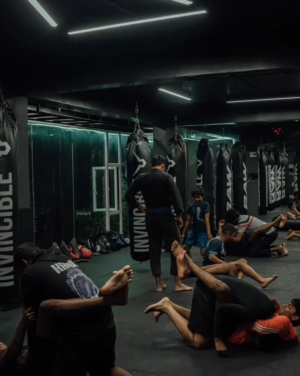 The floor is where the chess match of Jiu-Jitsu happens. Here you see a class practicing grappling techniques, learning how to control an opponent on the ground.
