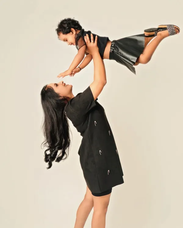 Pure, unfiltered joy! A mother lifting her daughter into the air is more than just a photo; it's a feeling of flight, freedom, and the incredible strength of a mother's love. These are the playful moments that define childhood.