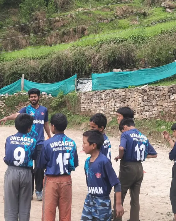 A typical coaching moment on the field in Grahan. I'm explaining a drill to the newly-formed team, all looking sharp in their Uncaged Football jerseys. Clear communication and focus are key to our training sessions.