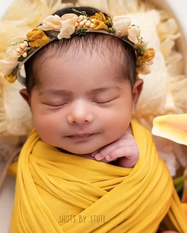 A sleepy smile from a sweet newborn. This is why I do what I do. These moments are so fleeting, and I feel honored to preserve them for you. This portrait was created using a soft yellow wrap and a delicate floral headband for a touch of sunshine.