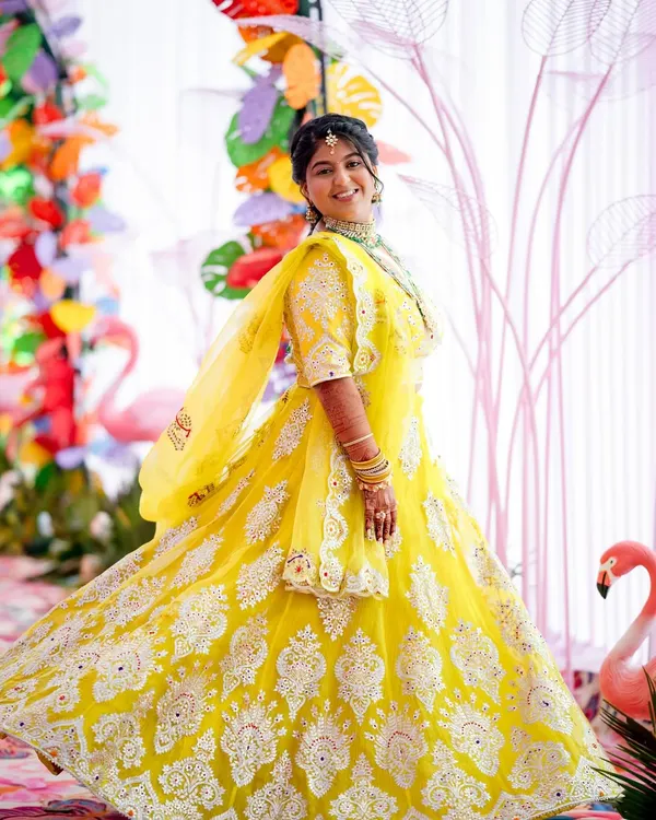 A radiant bride-to-be at her colorful Mayra celebration. Her bright yellow lehenga and joyful smile perfectly capture the spirit of this fun-filled pre-wedding event.