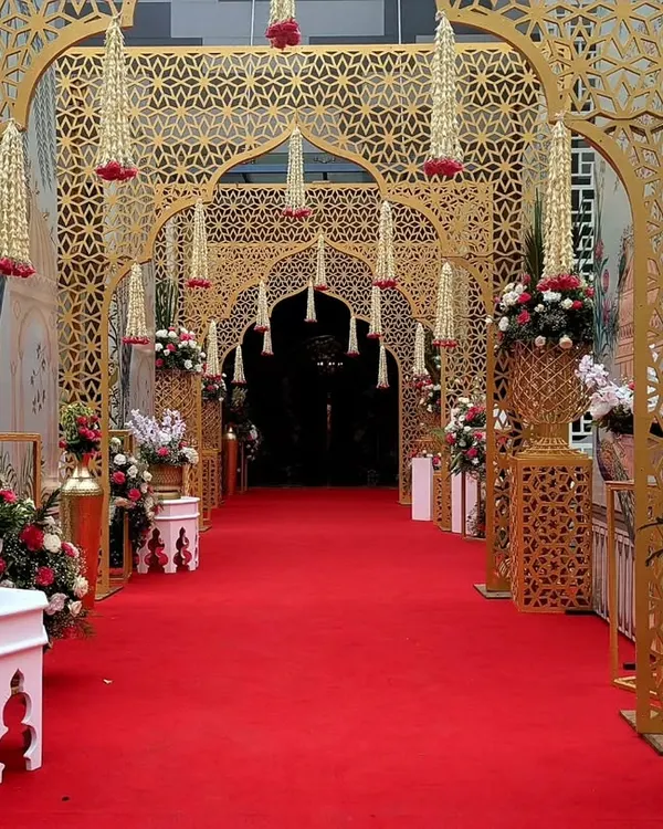 I designed this majestic entrance using a series of golden jaali arches, creating a royal passageway for guests. The intricate patterns and hanging floral tassels guide the eye, building a sense of grandeur and traditional opulence.