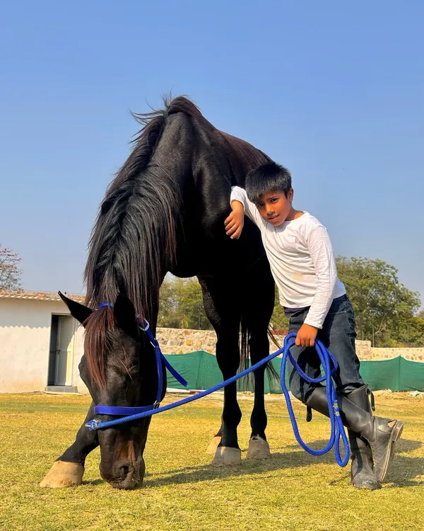 A young rider shares a quiet moment with one of our gentle black horses. I teach children not just to ride, but to connect with and respect these amazing animals.