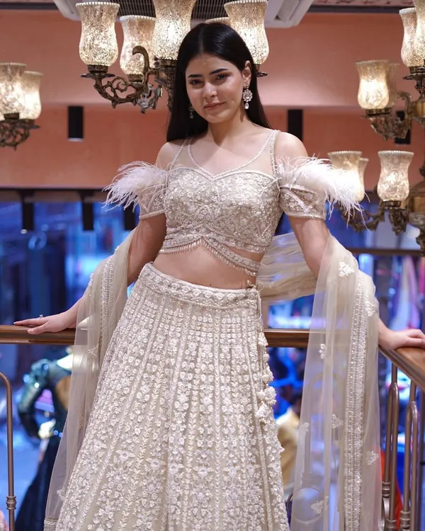 Drape yourself in opulence with this gold and white lehenga, featuring stunning feather sleeve detailing. It’s a masterpiece for the modern queen seeking a touch of glamour.