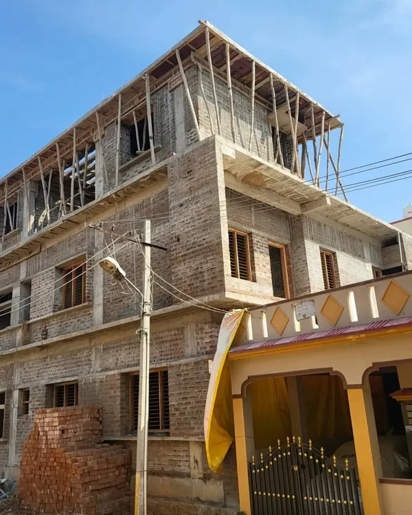The brickwork and structural frame of a multi-story bungalow under construction. This image shows the project taking shape according to our architectural plans.