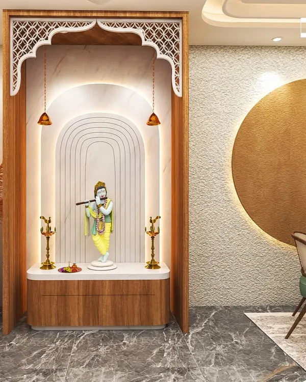 This elegant pooja room concept features a beautiful arch with traditional jaali work, soft backlighting, and a marble platform for the deity. The design is serene, spiritual, and seamlessly integrated into the home.