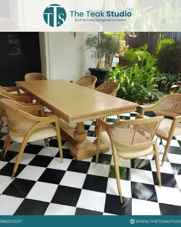 This beautiful eight-seater dining set was crafted for a farmhouse. The solid teak wood table with its classic pedestal base is paired with elegant chairs that feature natural rattan backs, creating a bright and welcoming outdoor dining feel.