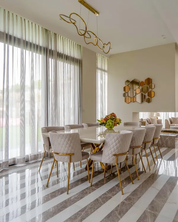 This peaceful dining area in a Chattarpur farmhouse is where minimalism and warmth create the perfect recipe. The striped Italian marble floor, beige and grey palette, and a touch of gold create a tranquil yet stylish atmosphere.