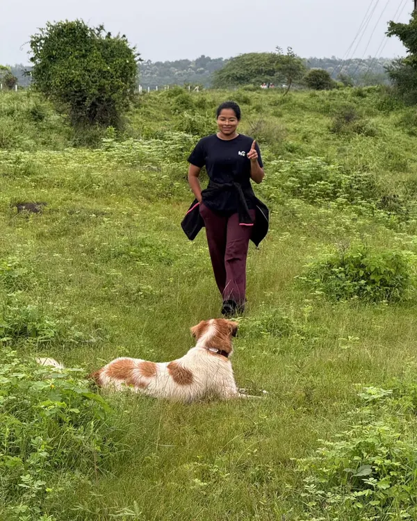 Leading a walk through a lush green field, with a happy and relaxed dog by my side. My adventure hikes are structured to let dogs be dogs, exploring nature while practicing calm behavior.