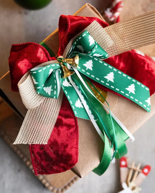 A beautifully wrapped gift is a joy to give and receive. This is an example of the kind of stunning, professional-level gift wrapping you can learn in my workshops, complete with layered bows and festive details.