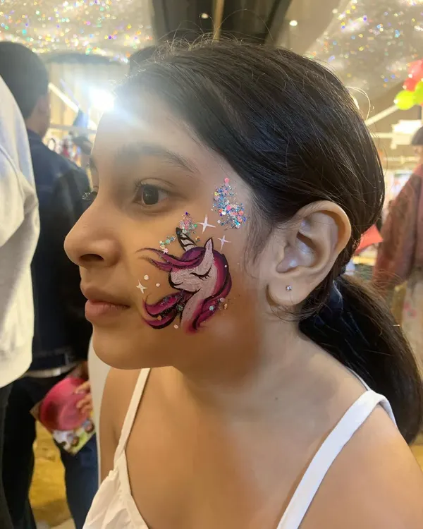 A close-up of our signature unicorn face paint, complete with magical glitter and sparkling stars. This is one of our most requested designs for birthday parties and brings so much joy to the little ones.